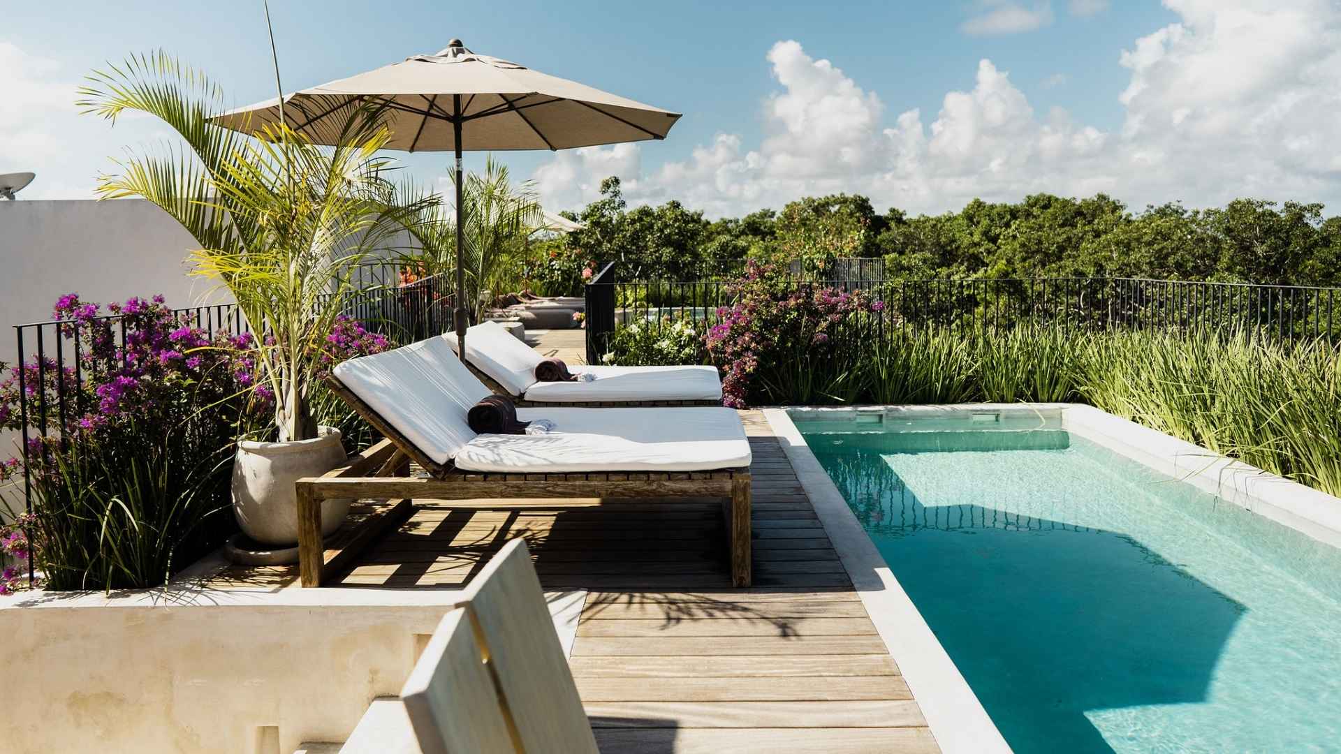 Loungers by the pool at Villa Imperia in Tulum, Mexico. 