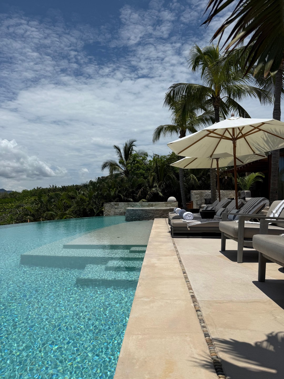 Poolside lounge chairs and umbrellas at Casa Roka Punta Mita luxury vacation villa