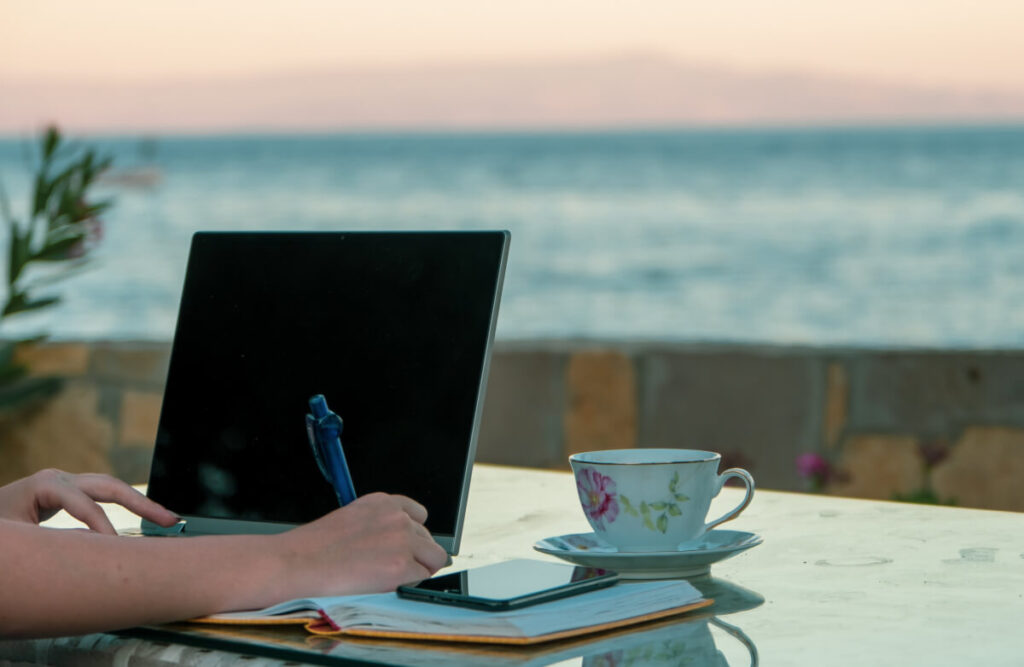 woman working home writing and taking notes at the beach