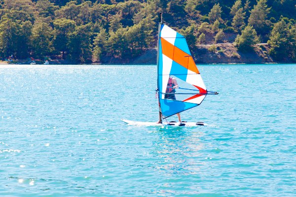 A windsurfer gliding across the clear waters of the East Cape